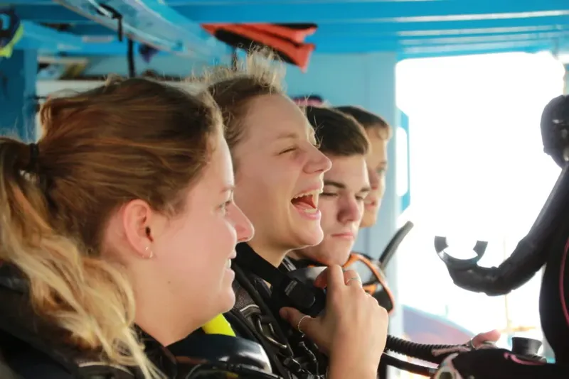 Plongeurs souriants sur un bateau, équipés et prêts à plonger