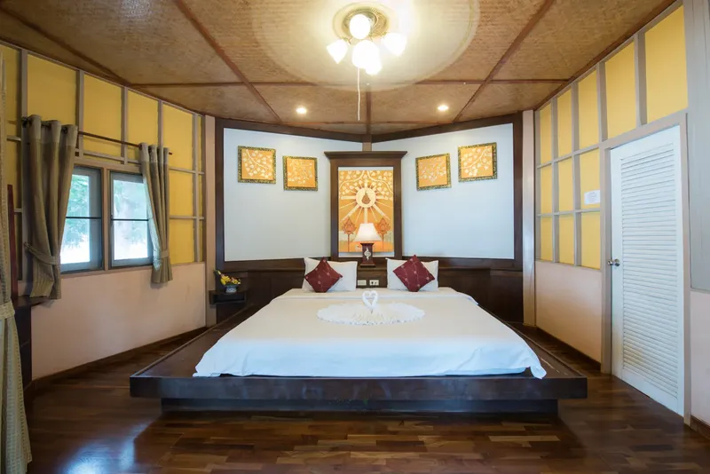 Chambre d'hôtel spacieuse avec un grand lit décoré de fleurs