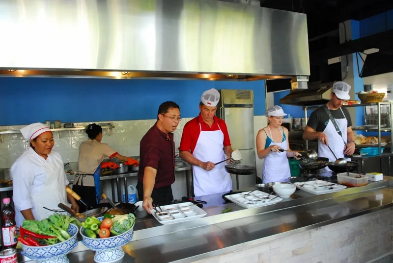 Cours de cuisine avec plusieurs personnes préparant des plats asiatiques