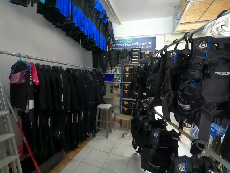 Rangées de combinaisons et gilets de plongée dans un local