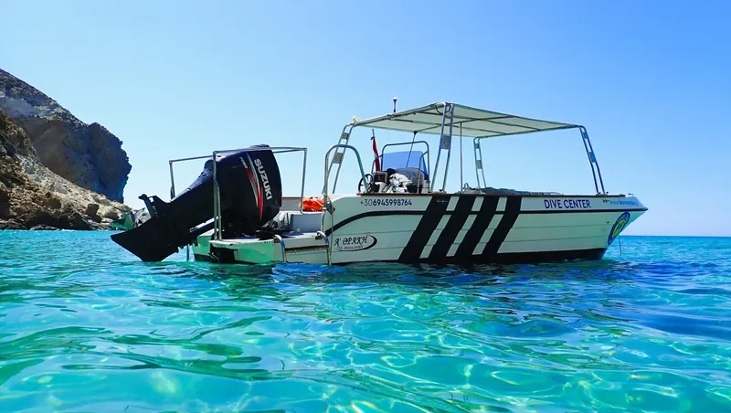 Bateau de plongée blanc et bleu sur une mer turquoise claire