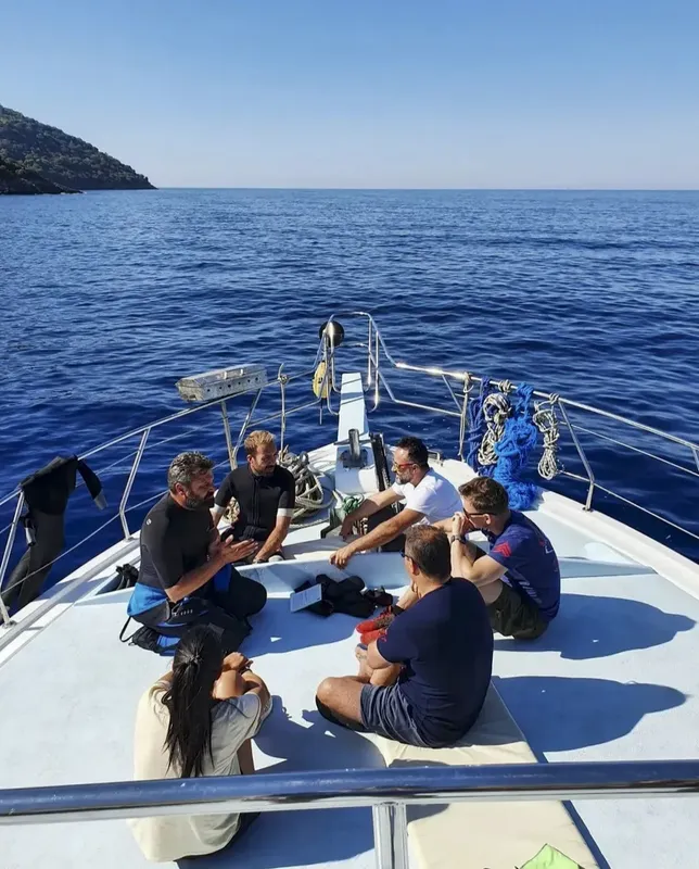 Groupe de personnes assises sur le pont d'un bateau de plongée