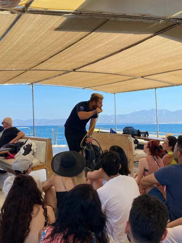 Groupe de personnes sur un bateau de plongée, briefing avant immersion