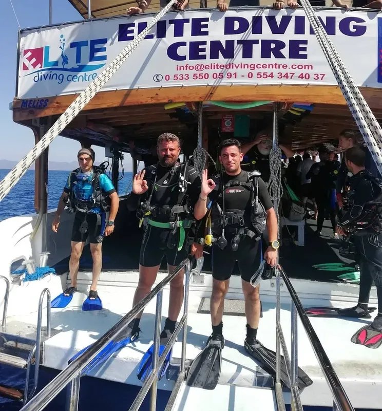 Plongeurs souriants sur un bateau de plongée en mer, équipement visible