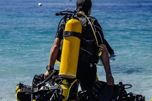 Plongeur préparant son équipement sur une plage ensoleillée