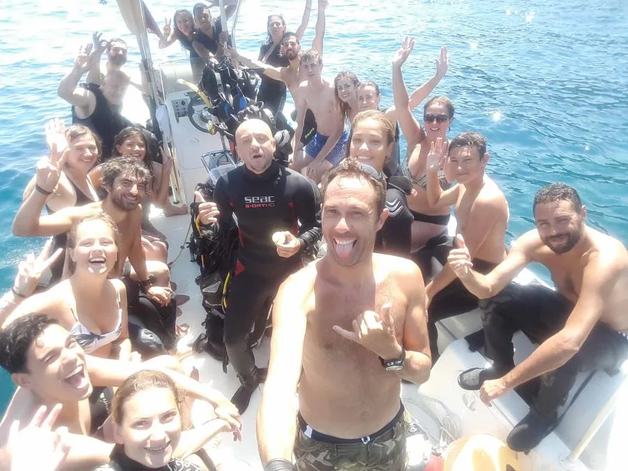 Groupe de plongeurs souriants à bord d'un bateau en mer