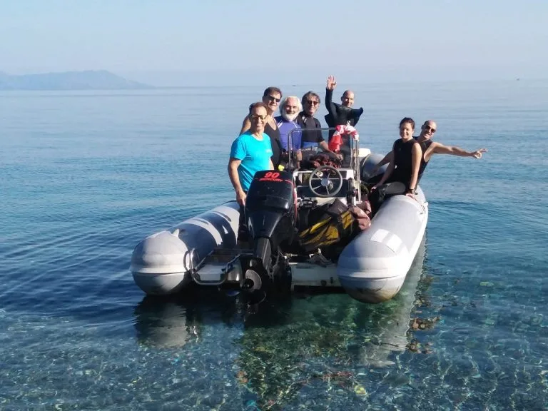 Groupe de personnes souriantes à bord d'un bateau semi-rigide en mer