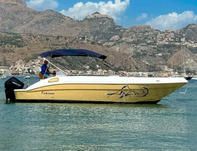 Bateau de plongée jaune en mer avec une personne à bord