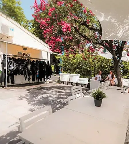Terrasse ombragée avec combinaisons de plongée et personnes assises