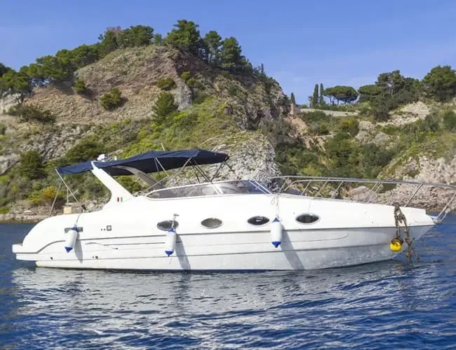 Bateau de plaisance blanc amarré dans une crique ensoleillée