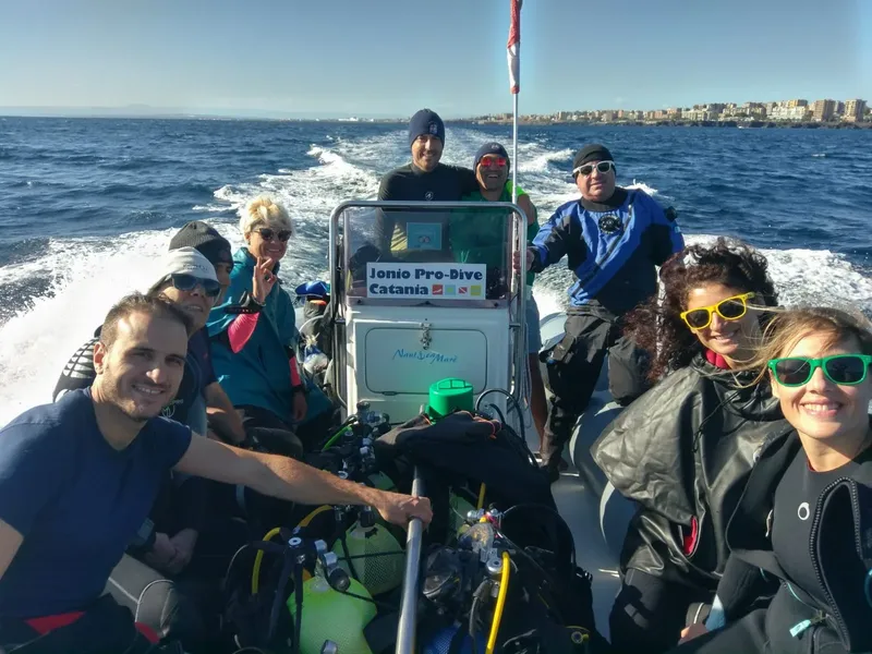 Groupe de plongeurs souriants sur un bateau en pleine mer