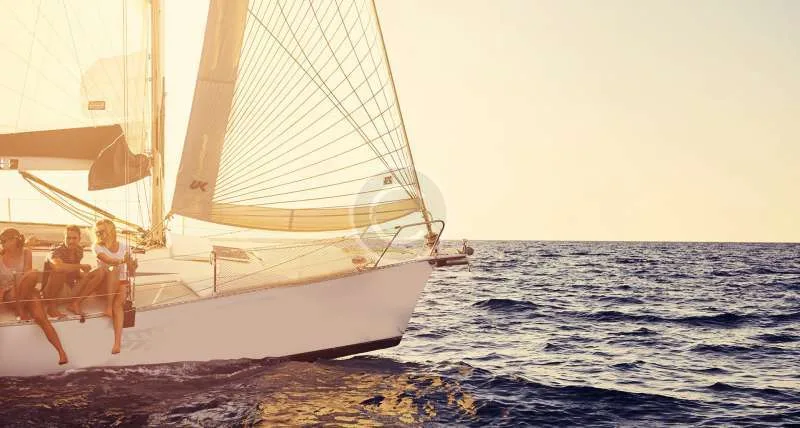 Quatre personnes assises sur un voilier en pleine mer