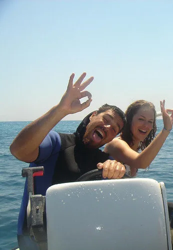 Deux plongeurs souriants sur un bateau en mer, geste de validation