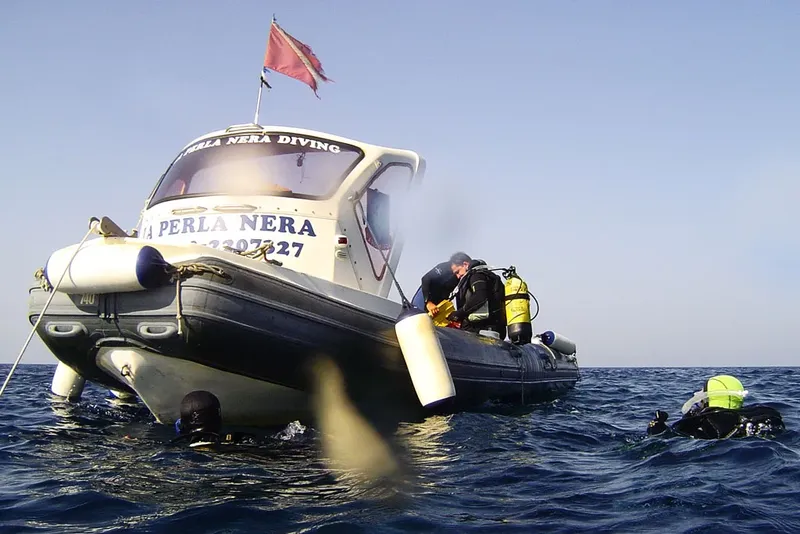 Bateau de plongée avec des plongeurs préparant leur matériel en mer