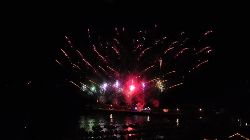 Feux d'artifice colorés illuminent le ciel nocturne au-dessus de l'eau