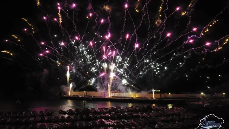 Feux d'artifice colorés illuminent le port et les bateaux amarrés