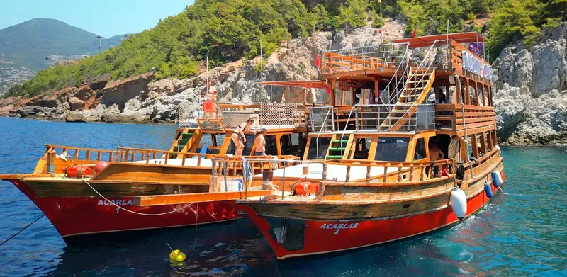 Deux bateaux de plongée amarrés dans une crique turquoise avec des passagers