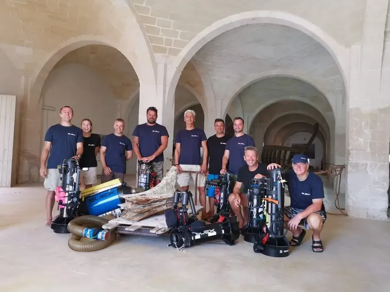 Groupe de plongeurs souriants posant avec leur équipement complet