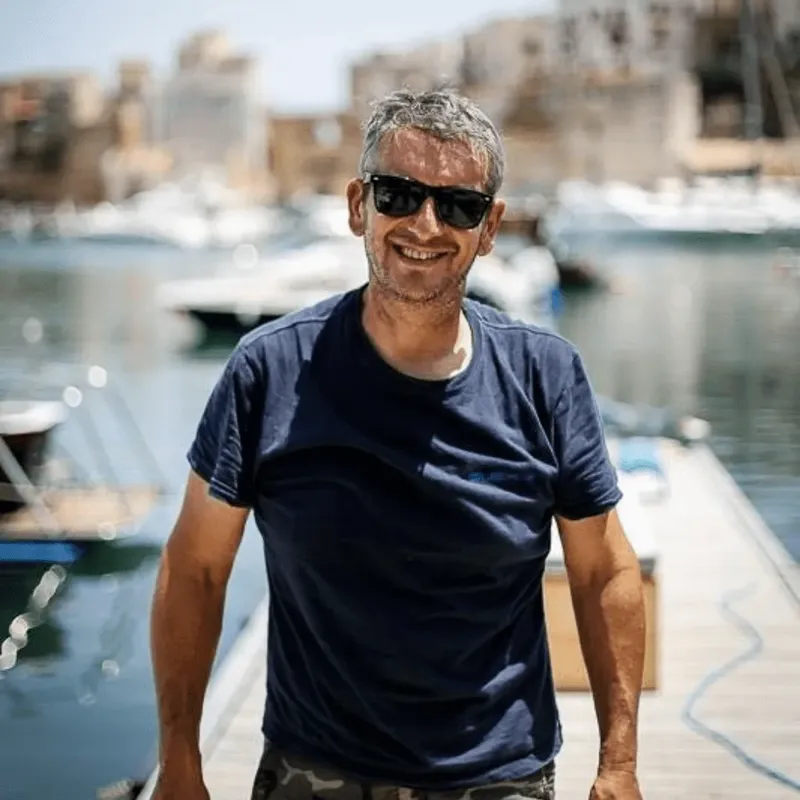 Homme souriant avec lunettes de soleil sur un ponton ensoleillé