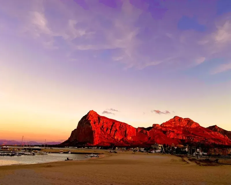 Paysage marin avec montagnes illuminées au coucher du soleil et bateaux
