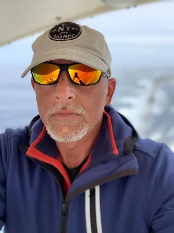 Homme portant une casquette et des lunettes de soleil sur un bateau