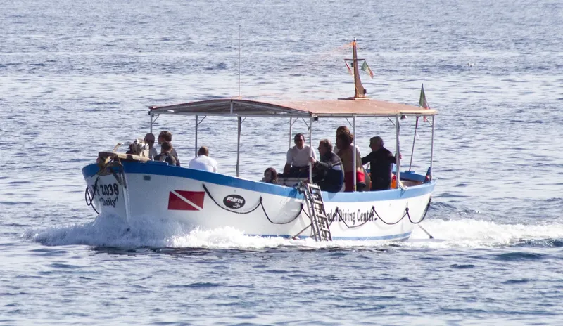 Bateau de plongée bleu avec des passagers en mer calme