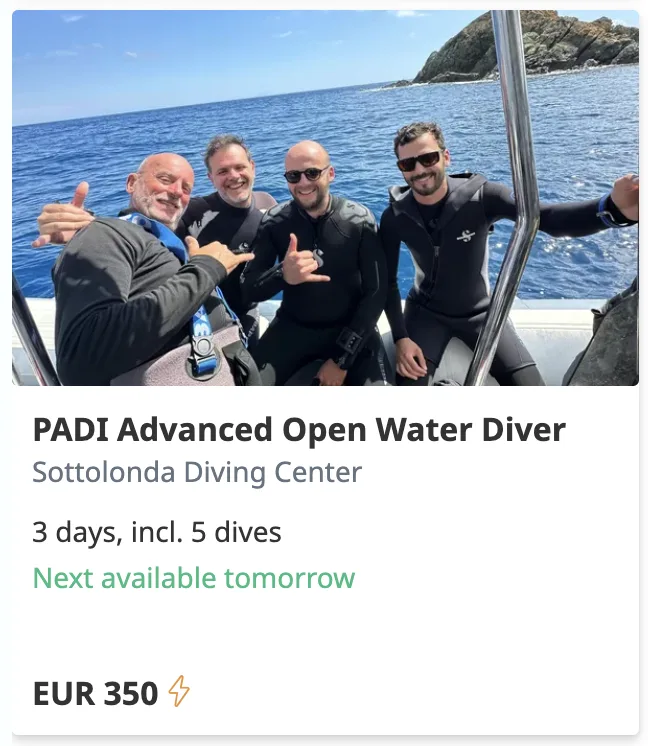 Quatre plongeurs souriants sur un bateau en mer, signe de succès