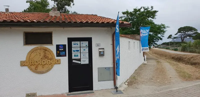Façade d'un centre de plongée avec enseigne et drapeaux PADI