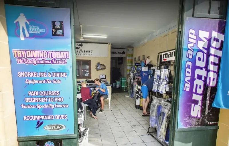 Entrée d'un centre de plongée avec du matériel et des personnes assises