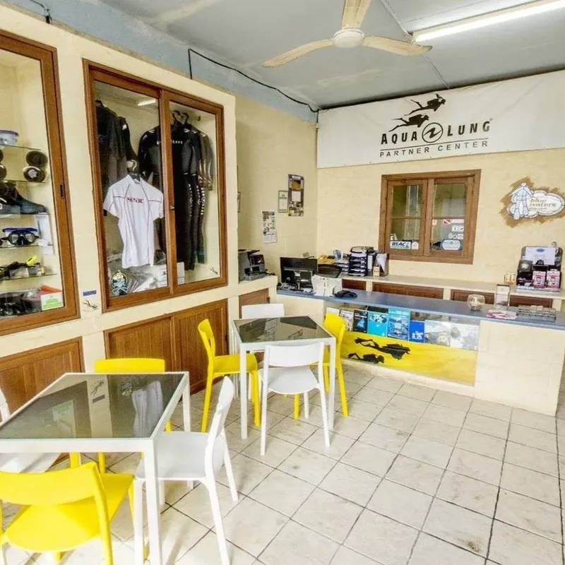 Intérieur d'un centre de plongée avec matériel, tables et logo Aqualung