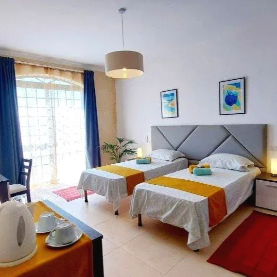 Chambre d'hôtel avec deux lits simples, décoration sobre et lumineuse