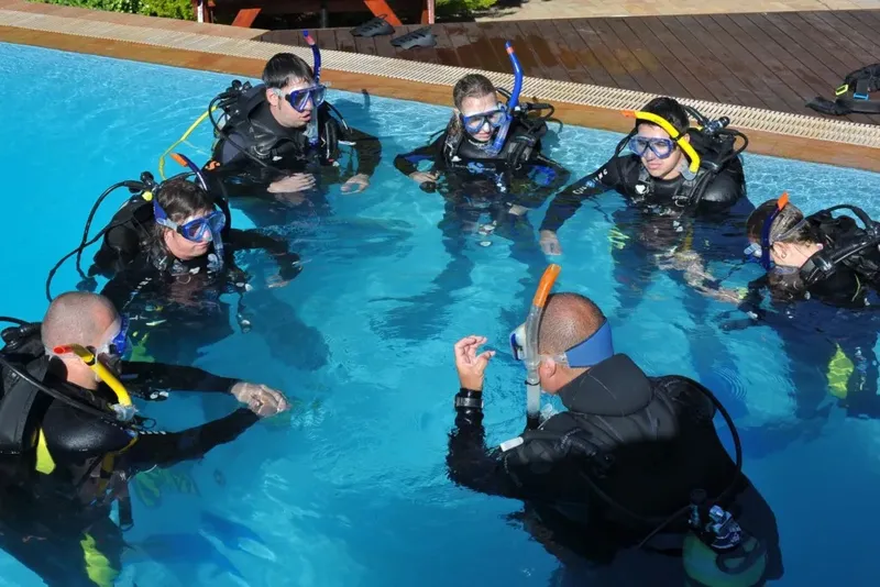 Groupe de plongeurs en formation dans une piscine, équipement complet