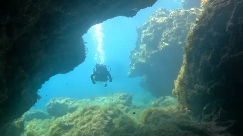 Plongeur explore une grotte sous-marine avec une lumière descendante