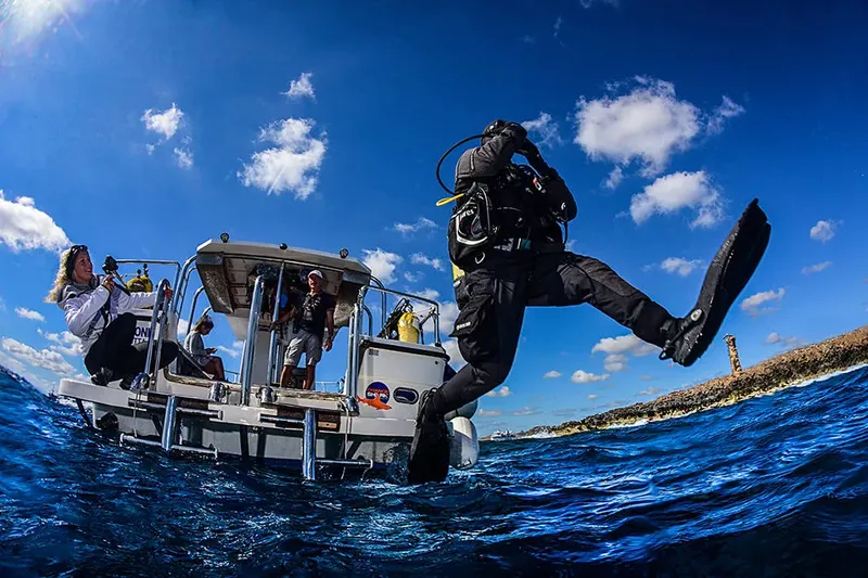 Plongeur s'apprêtant à sauter d'un bateau de plongée en mer