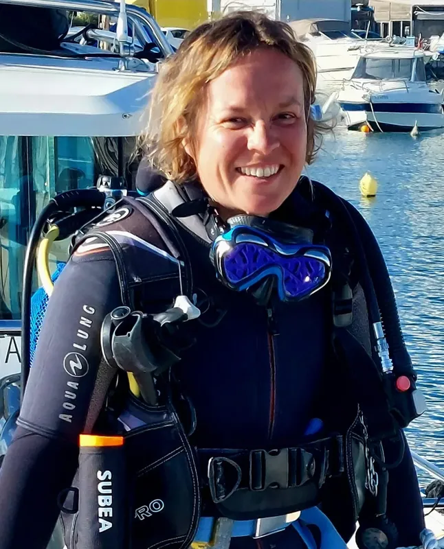 Plongeuse souriante avec équipement complet prête pour une immersion