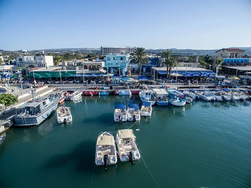 Port de plaisance ensoleillé avec bateaux amarrés et bâtiments colorés