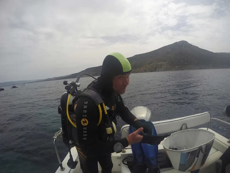 Plongeur équipé sur un bateau, prêt à entrer dans l'eau