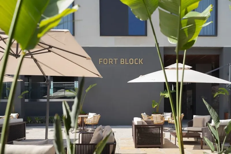 Terrasse ombragée avec mobilier de jardin devant un bâtiment moderne