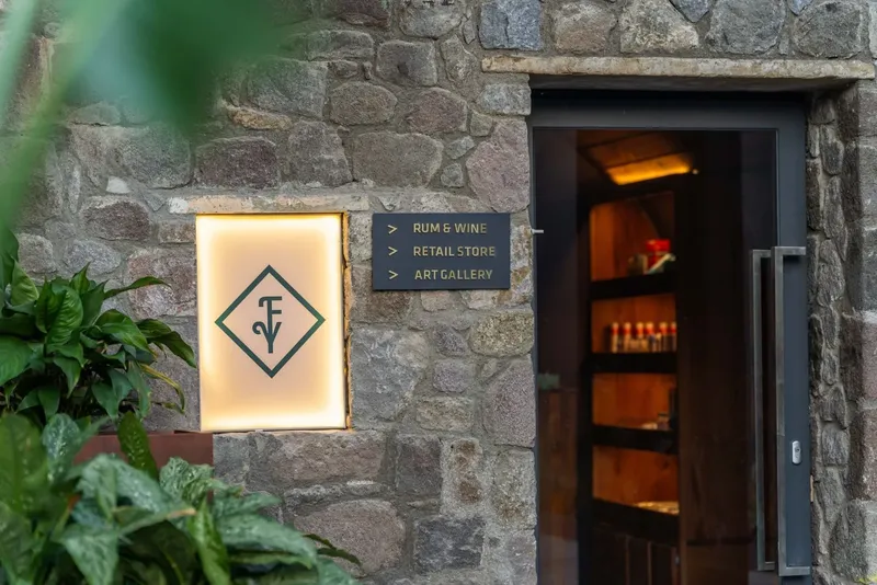 Façade en pierre avec enseigne lumineuse et indications vers différents espaces