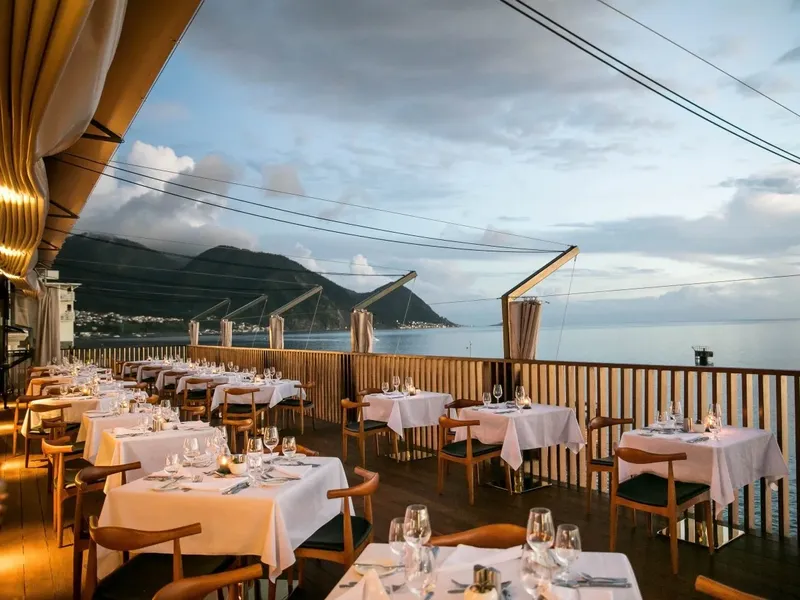 Terrasse de restaurant avec vue sur la mer et les montagnes