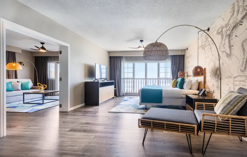 Chambre d'hôtel spacieuse avec salon, lit et vue sur mer