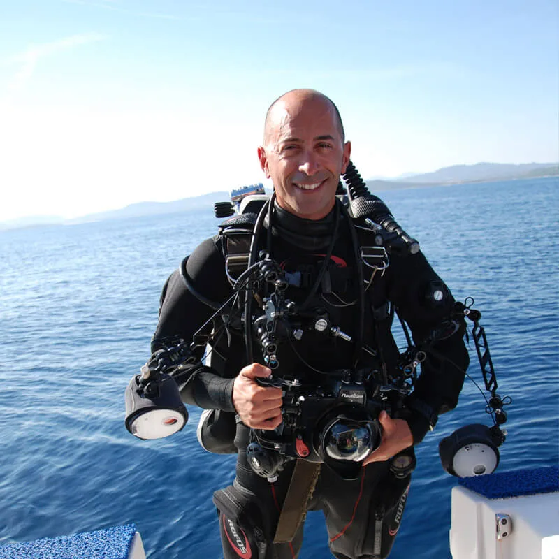 Plongeur souriant en combinaison complète sur un bateau en mer