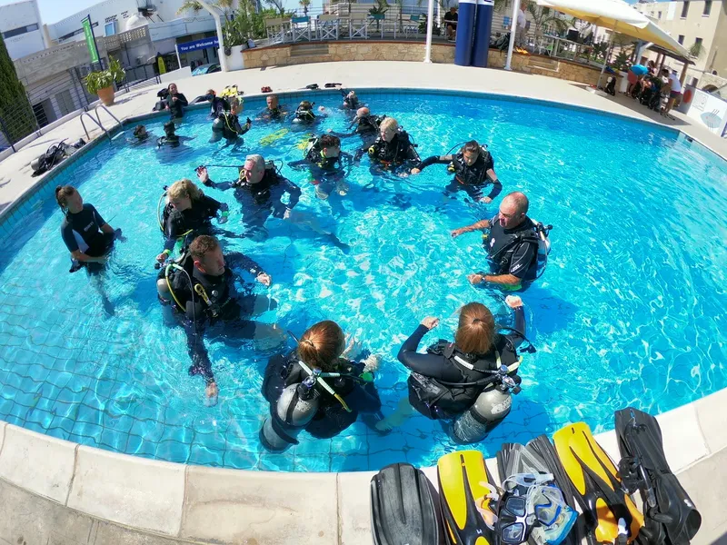 Groupe de plongeurs en formation dans une piscine avec équipement complet