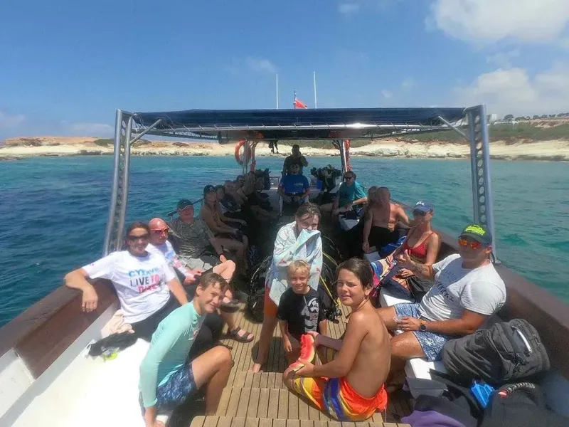 Groupe de plongeurs souriants à bord d'un bateau en mer