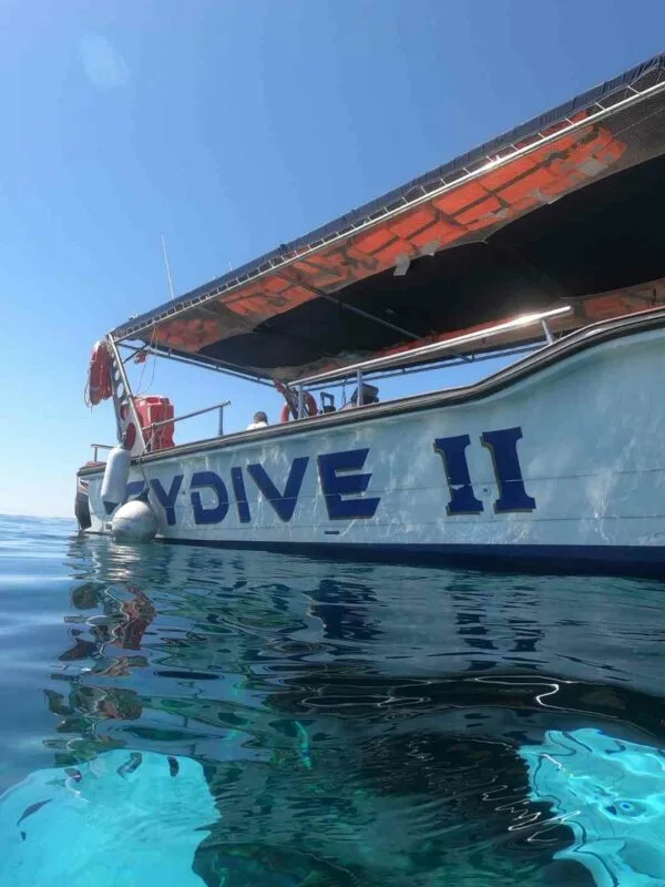 Bateau de plongée blanc et orange sur une mer turquoise calme