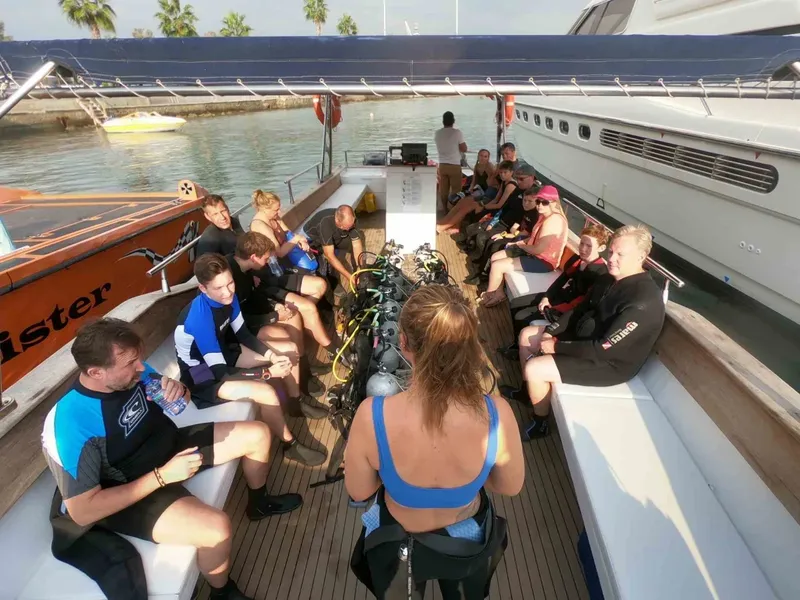 Groupe de plongeurs assis sur un bateau de plongée en préparation