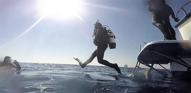Plongeur s'apprête à sauter d'un bateau en pleine mer