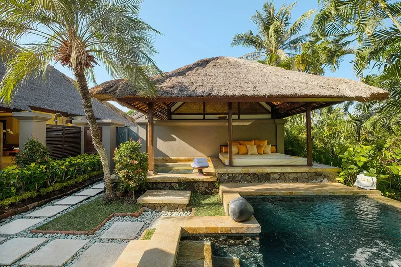 Pavillon de relaxation en extérieur avec toit de chaume et piscine