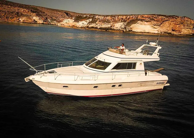 Bateau de plaisance blanc naviguant sur une mer calme près des côtes