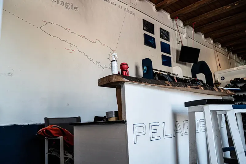 Intérieur d'un centre de plongée avec comptoir, carte et équipement